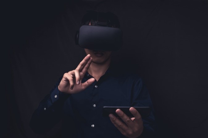 man wearing VR headset and holding cell phone