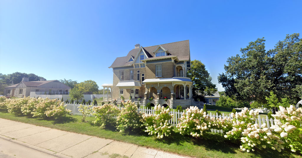 Victorian-era home with porch in Janesville's Courthouse Hill district.