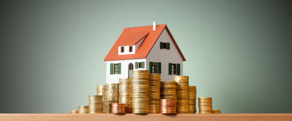 A small decorative house model surrounded by gold coins symbolizing rising home value.