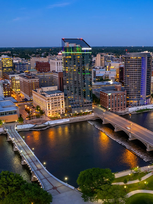 Twilight view of downtown Grand Rapids, Michigan, showing bridges crossing the Grand River.