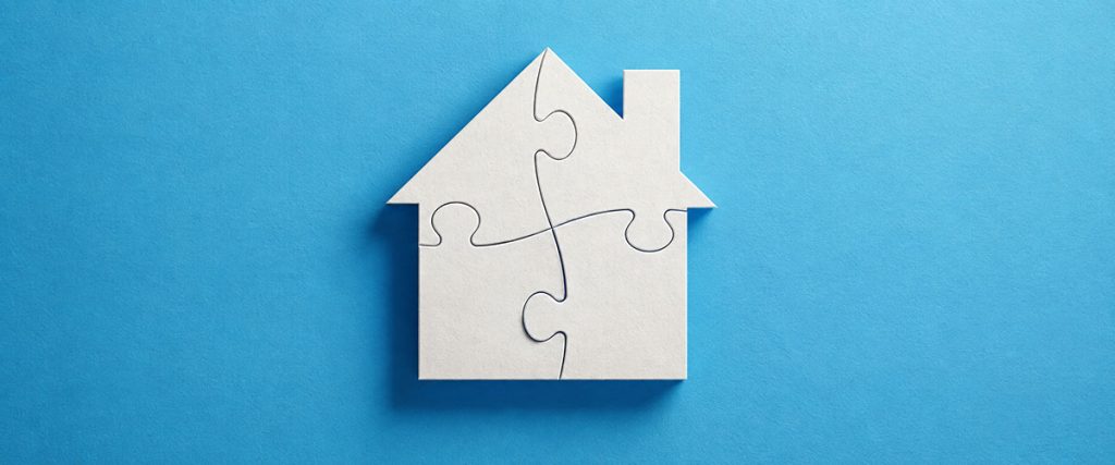 White house made of four interlocking puzzle pieces on a blue background.