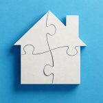 White house made of four interlocking puzzle pieces on a blue background.