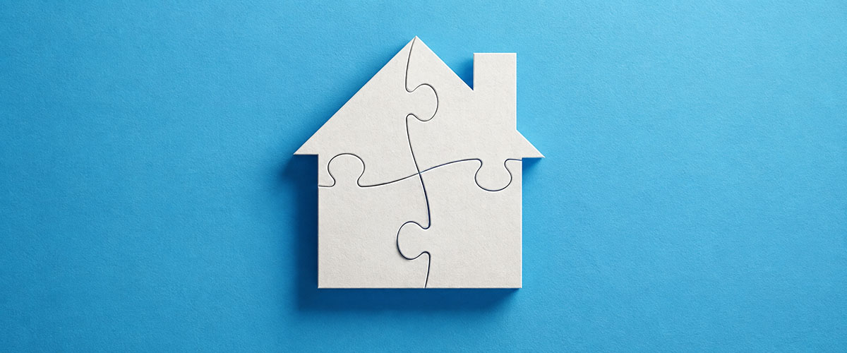 White house made of four interlocking puzzle pieces on a blue background.