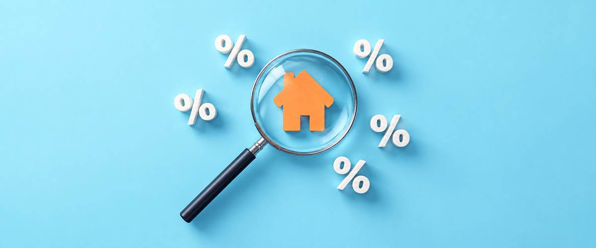 Magnifying glass over an orange house icon surrounded by percent symbols.